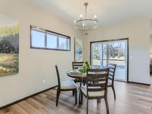 dining space featuring light hardwood / wood-style flooring and a notable chandelier