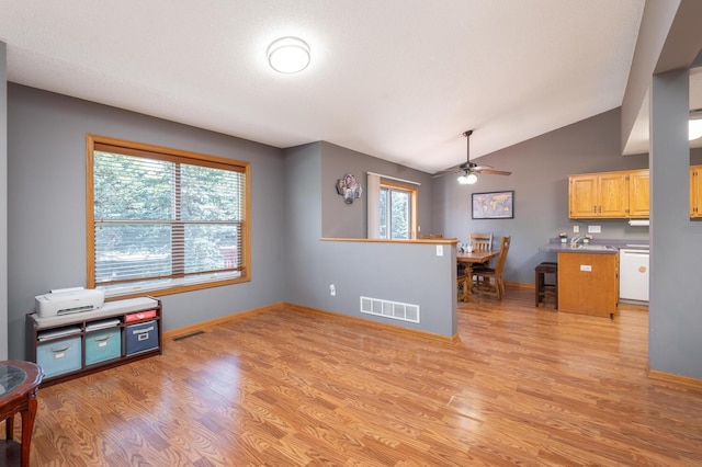 interior space with lofted ceiling, sink, light hardwood / wood-style flooring, and light brown cabinets