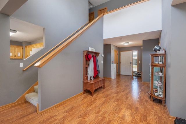 stairway with a towering ceiling and wood-type flooring