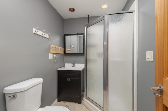 bathroom with a shower with door, vanity, tile patterned flooring, and toilet