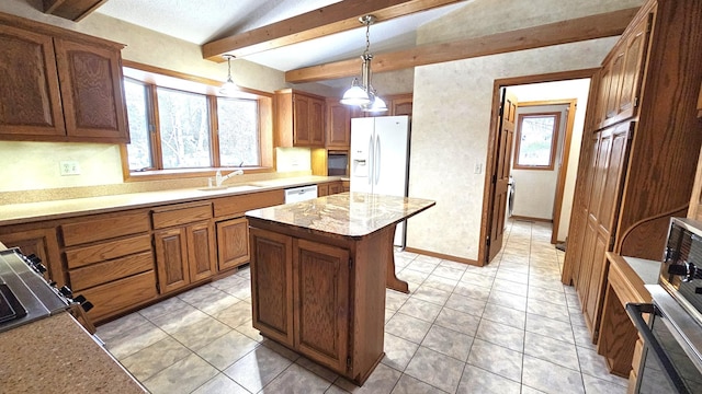 kitchen featuring a kitchen island, lofted ceiling with beams, sink, hanging light fixtures, and white appliances