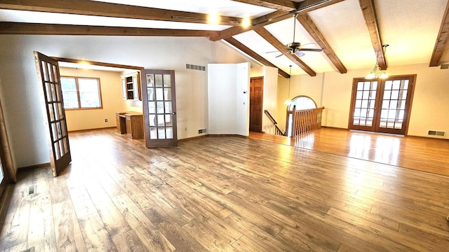 unfurnished living room featuring visible vents, french doors, vaulted ceiling with beams, and wood-type flooring