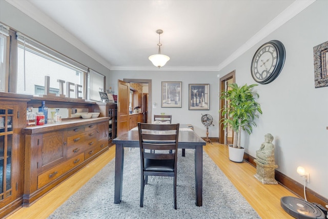 dining room with baseboards, light wood-style floors, and ornamental molding