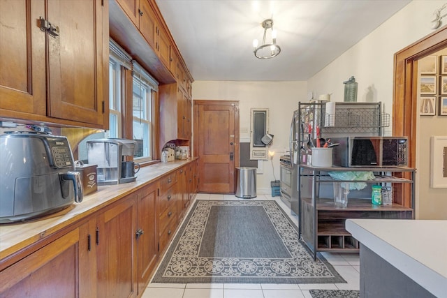 kitchen with light tile patterned floors and brown cabinetry