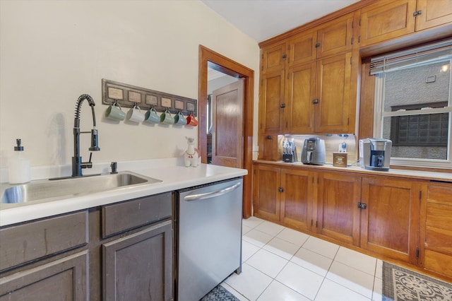 kitchen featuring dishwasher, light countertops, brown cabinetry, and a sink