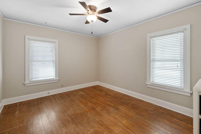 empty room with a wealth of natural light, ceiling fan, baseboards, and hardwood / wood-style flooring