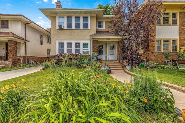 view of front of home featuring brick siding, stucco siding, a chimney, and a front yard