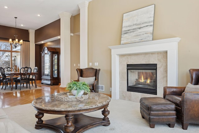 living room featuring light hardwood / wood-style flooring, a fireplace, and a chandelier