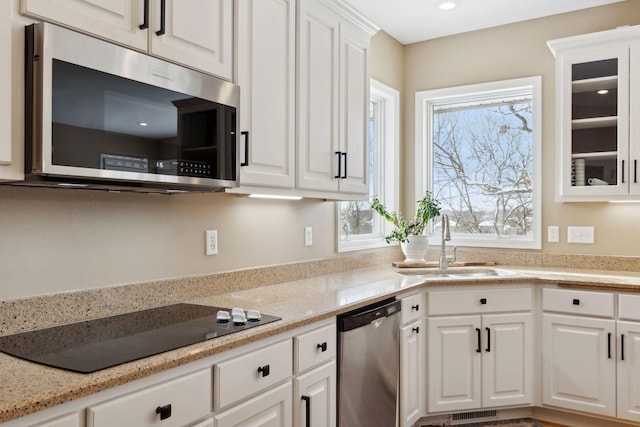 kitchen with sink, stainless steel appliances, and white cabinets