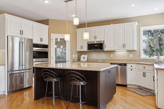 kitchen featuring white cabinetry, sink, stainless steel appliances, and a center island