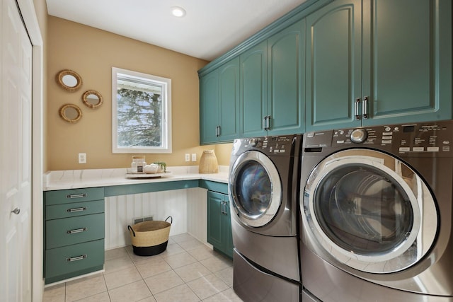 laundry room with cabinets, light tile patterned flooring, and washer and clothes dryer