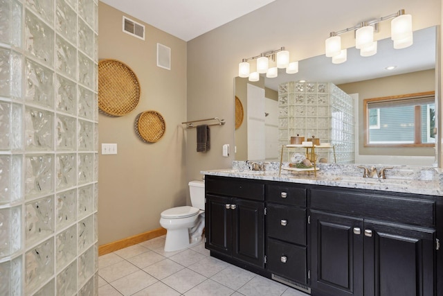 bathroom featuring walk in shower, vanity, toilet, and tile patterned flooring