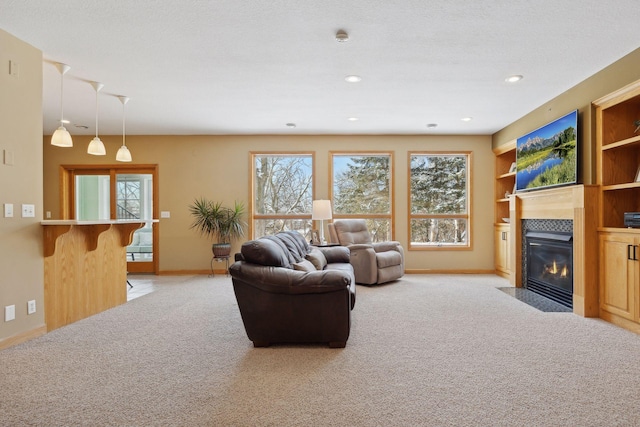 carpeted living room featuring built in shelves, a fireplace, and a textured ceiling