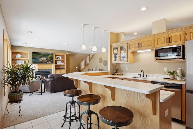 kitchen with a breakfast bar area, built in features, kitchen peninsula, and dishwasher