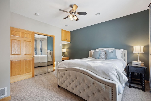 carpeted bedroom featuring a closet and ceiling fan