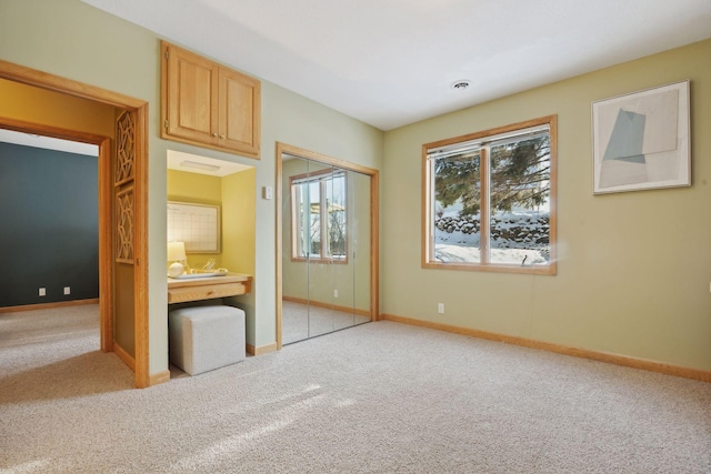 unfurnished bedroom with light colored carpet and a closet