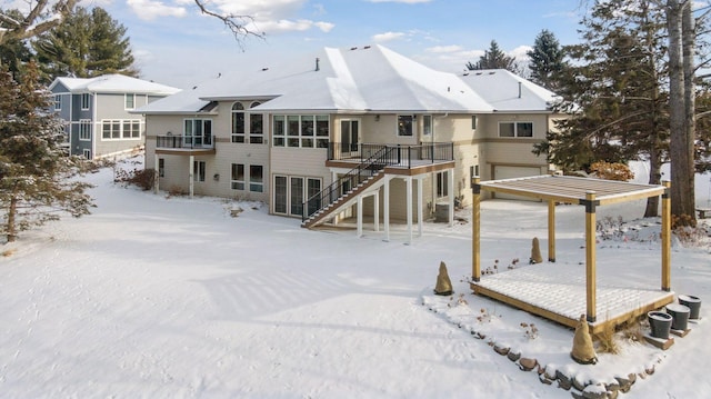 snow covered rear of property featuring a wooden deck