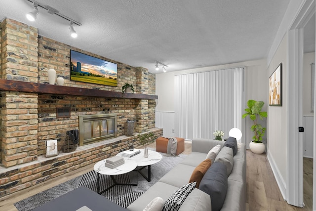 living room with hardwood / wood-style flooring, a fireplace, and a textured ceiling