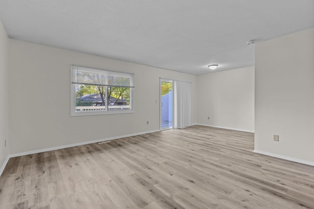 unfurnished room with light hardwood / wood-style floors and a textured ceiling