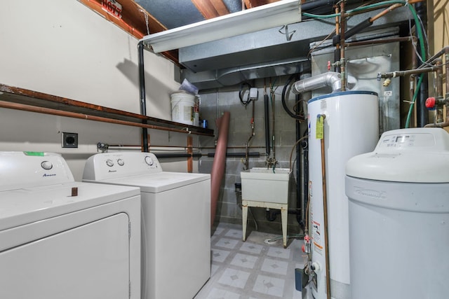 washroom with sink, washing machine and dryer, and water heater