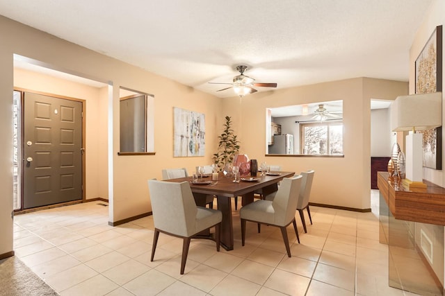 tiled dining room featuring a textured ceiling and ceiling fan