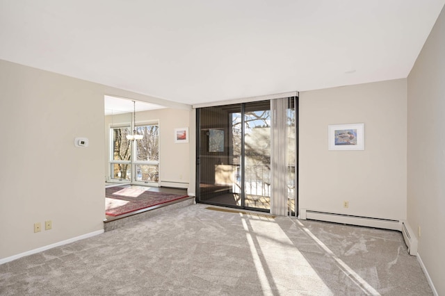 empty room featuring a baseboard radiator, a notable chandelier, and carpet flooring