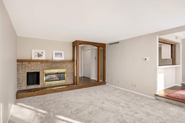 unfurnished living room with a brick fireplace and carpet floors