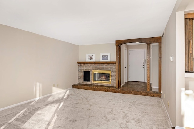 unfurnished living room featuring carpet floors and a brick fireplace