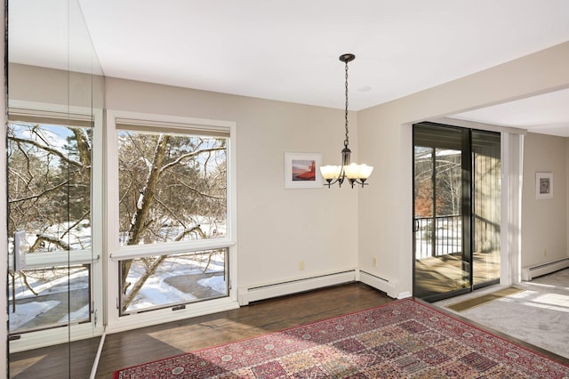 unfurnished dining area featuring baseboard heating, a wealth of natural light, and a notable chandelier