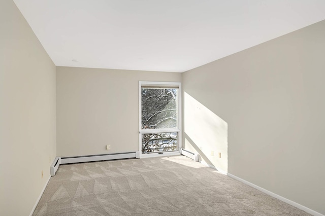 empty room with a baseboard heating unit and light colored carpet