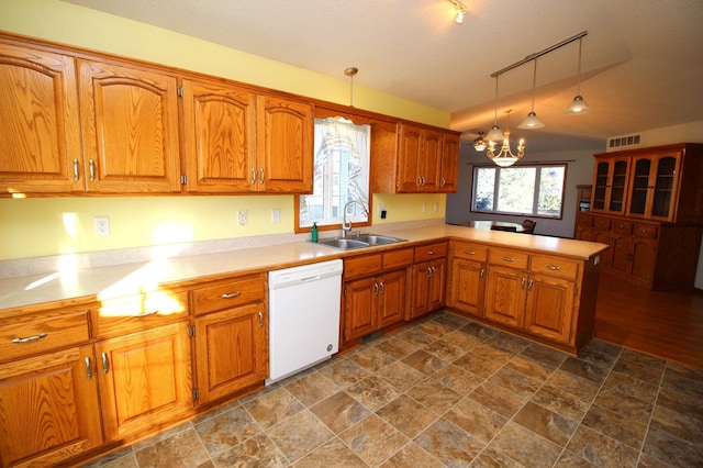 kitchen with sink, hanging light fixtures, kitchen peninsula, white dishwasher, and track lighting