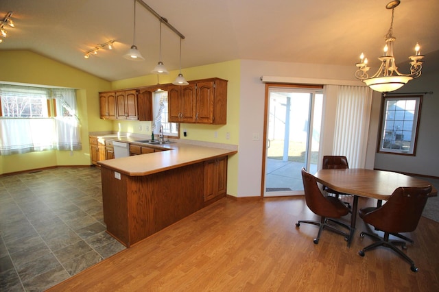 kitchen with pendant lighting, kitchen peninsula, sink, and white dishwasher