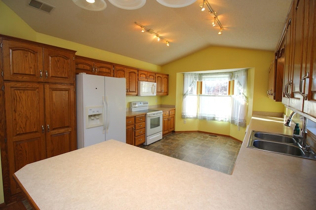 kitchen featuring white appliances, vaulted ceiling, and sink