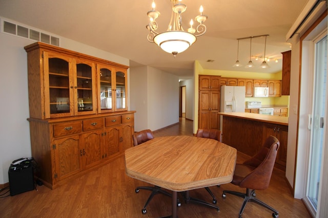 dining area featuring an inviting chandelier and light hardwood / wood-style flooring