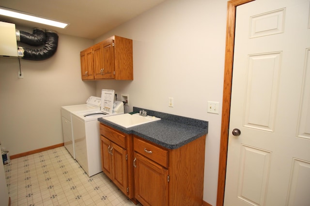 washroom with cabinets, separate washer and dryer, and sink