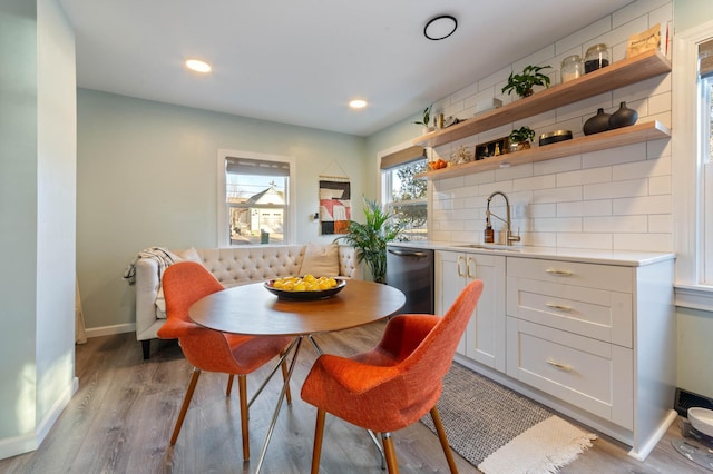 dining area with breakfast area, light hardwood / wood-style flooring, and sink