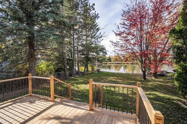 wooden terrace with a water view and a yard