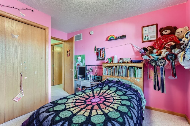 bedroom featuring light carpet, a textured ceiling, and a closet