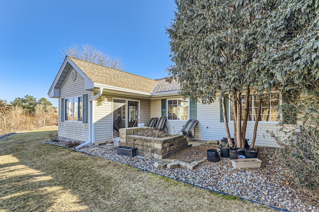 view of front of property with a front lawn and roof with shingles