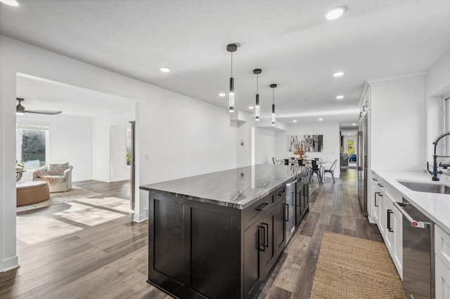 kitchen featuring sink, hanging light fixtures, stainless steel appliances, hardwood / wood-style floors, and white cabinets