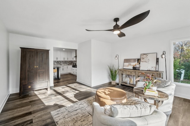 living room featuring ceiling fan and dark hardwood / wood-style flooring