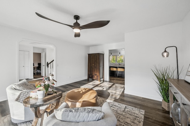 living room with ceiling fan and dark hardwood / wood-style flooring