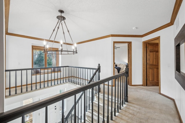 corridor featuring light carpet, a textured ceiling, a chandelier, and crown molding