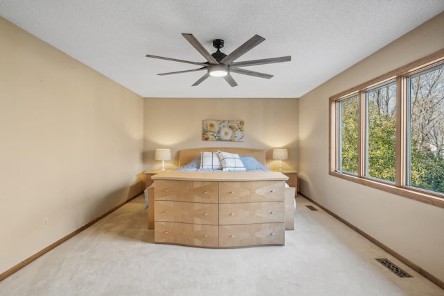 bedroom with carpet flooring, ceiling fan, and a textured ceiling