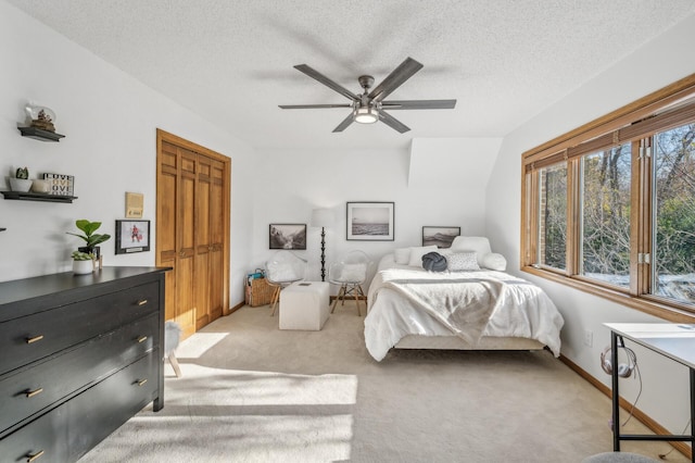 carpeted bedroom with a textured ceiling, a closet, and ceiling fan