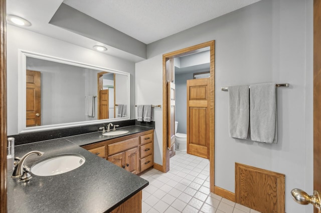 bathroom with tile patterned floors, vanity, and toilet