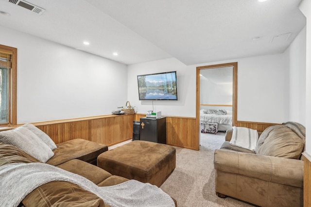 carpeted living room with wooden walls