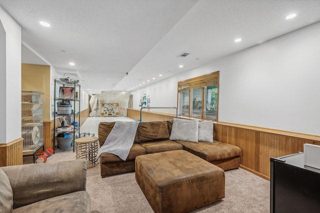 carpeted living room featuring wooden walls