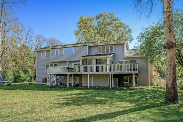 back of property featuring a yard, a deck, and a sunroom