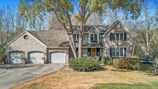 view of front of home featuring a trampoline, a garage, and a front lawn